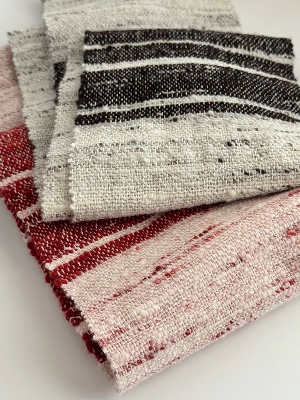 Close-up of folded textured fabric with black and red stripes.