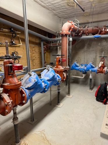 Industrial water control valves and pipes in a maintenance room.