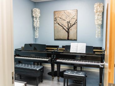 Well-equipped piano studio with acoustic instruments at Artistry Academy.