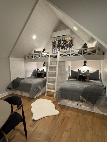 Cozy attic bedroom with bunk beds and bear-themed decor. Brigid McIntyre created this unque "bear den" for her client's grandchildren.  Luxury interiors doesn't always mean high brow, it means authentic and in sync with how the client lives.
