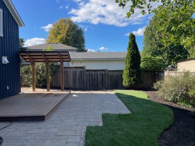 Backyard with patio and green lawn.