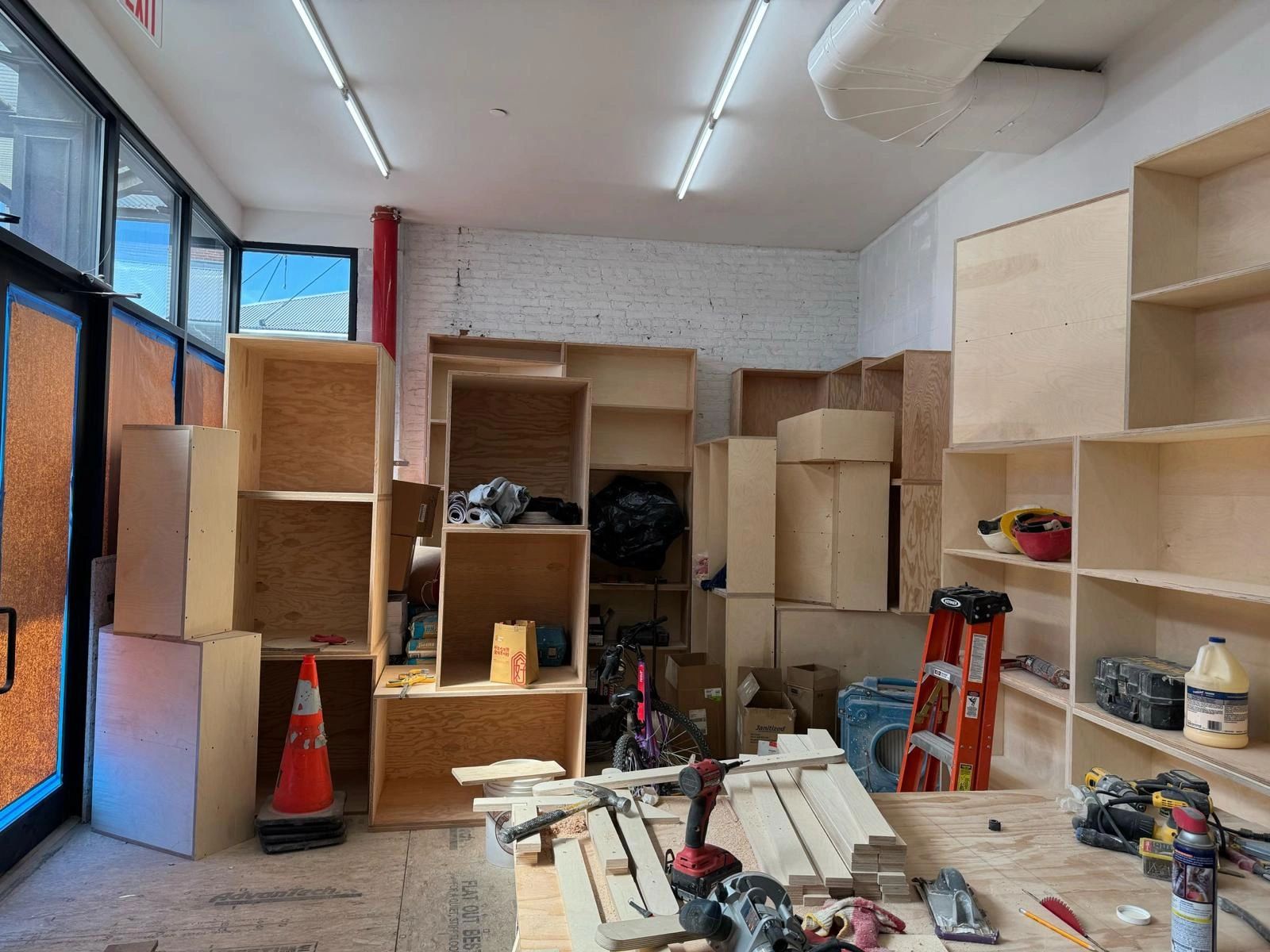 Workshop with wooden shelves, tools, and construction materials in progress.