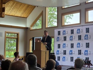 Nolan Kemp Candidate for IL74 speaking at JFK Dinner PAC event inside a room.