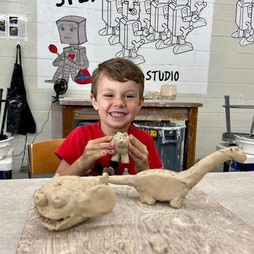 a little boy at the clay class with his creation