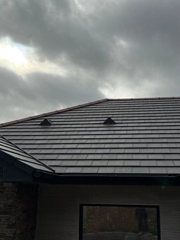 Dark cloudy sky over a tiled roof of a modern house.