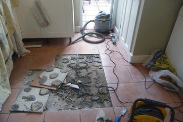 Loose tile on the kitchen floor caused by employing improper tiling techniques and materials