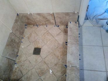 Completed shower pan installation, highlighting the smooth tile surface featuring a diagonal pattern