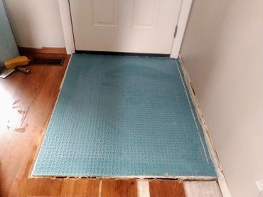 Fully installed anti-crack uncoupling membrane over a reinforced timber subfloor installation