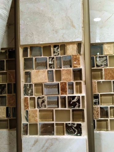 Poorly installed mosaic tiles with uneven alignment and visible gaps, showcasing bad craftsmanship