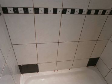 Shower wall structural repair with new waterproof board, reinstalled black tiles in Brownstown, MI