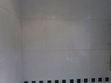 Macro view of 3/8-inch precision grout joints on a natural stone tile wall.