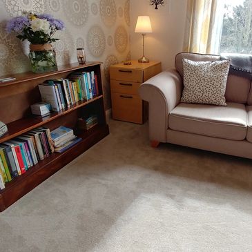 An image of the therapy room, showing a sofa and a bookcase.