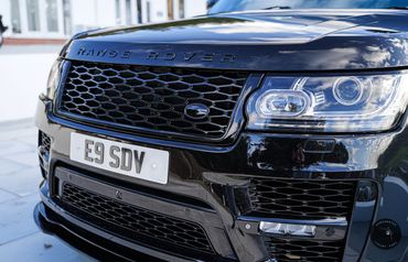 Close-up of Range Rover Vogue for hire iconic front grille, a mark of luxury.