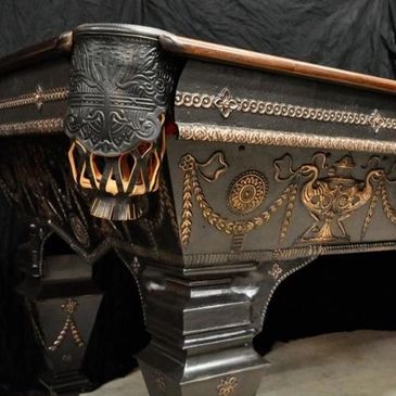 Vintage black and gold pool table with ornate and elaborate carvings