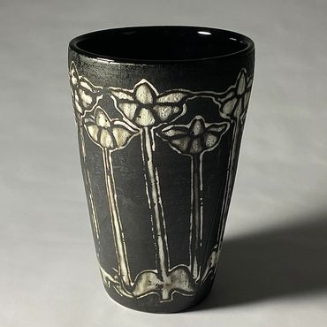 Black ceramic vase with white flower design. Black interior.