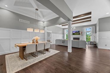Spacious modern dining and living area with neutral tones and wooden accents.