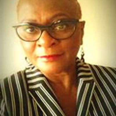 Woman wearing glasses and a striped jacket.