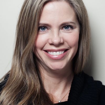 Smiling woman with long light brown hair and blue eyes.