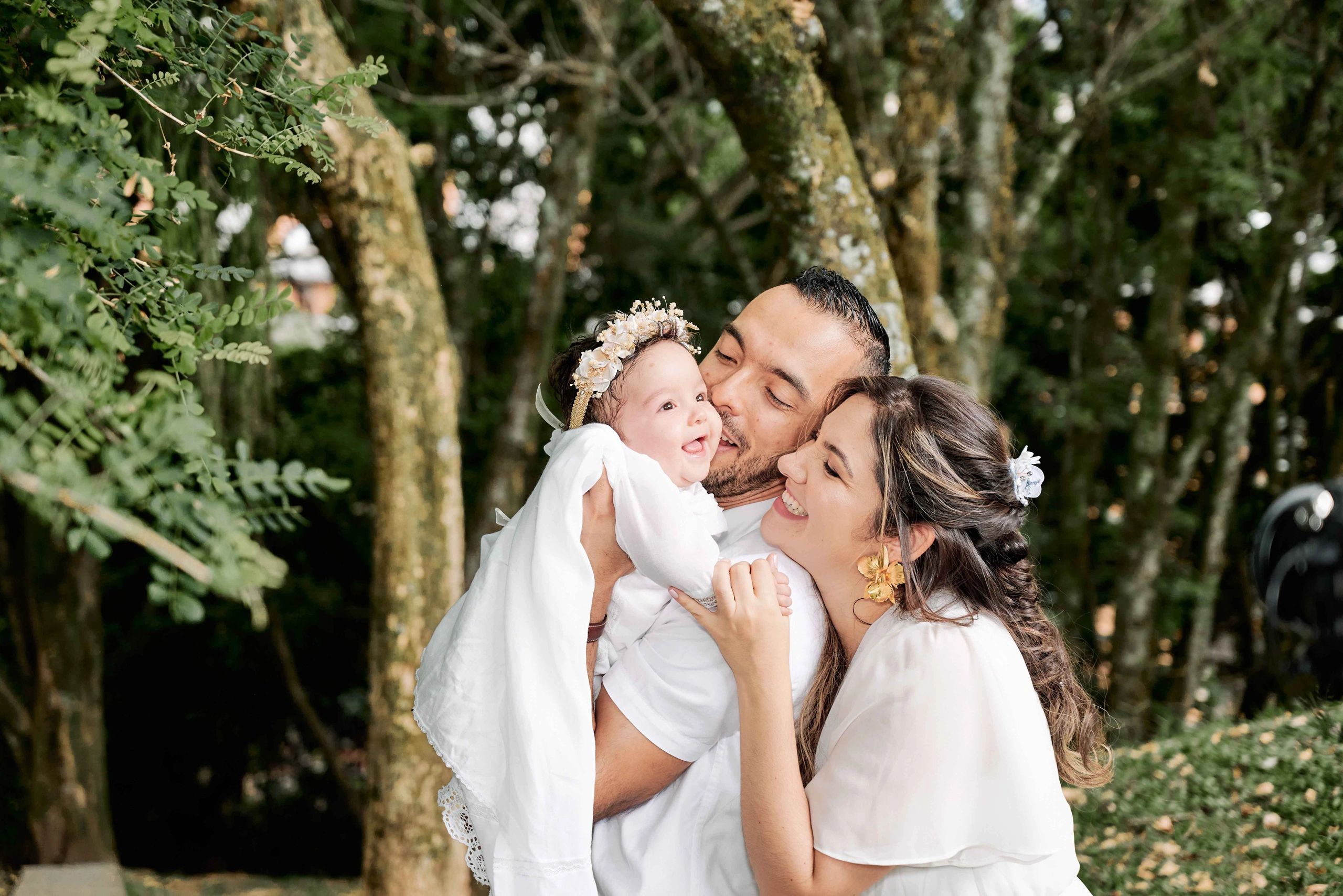 Familia celebrando el bautizo de su bebé en medio de un bosque
