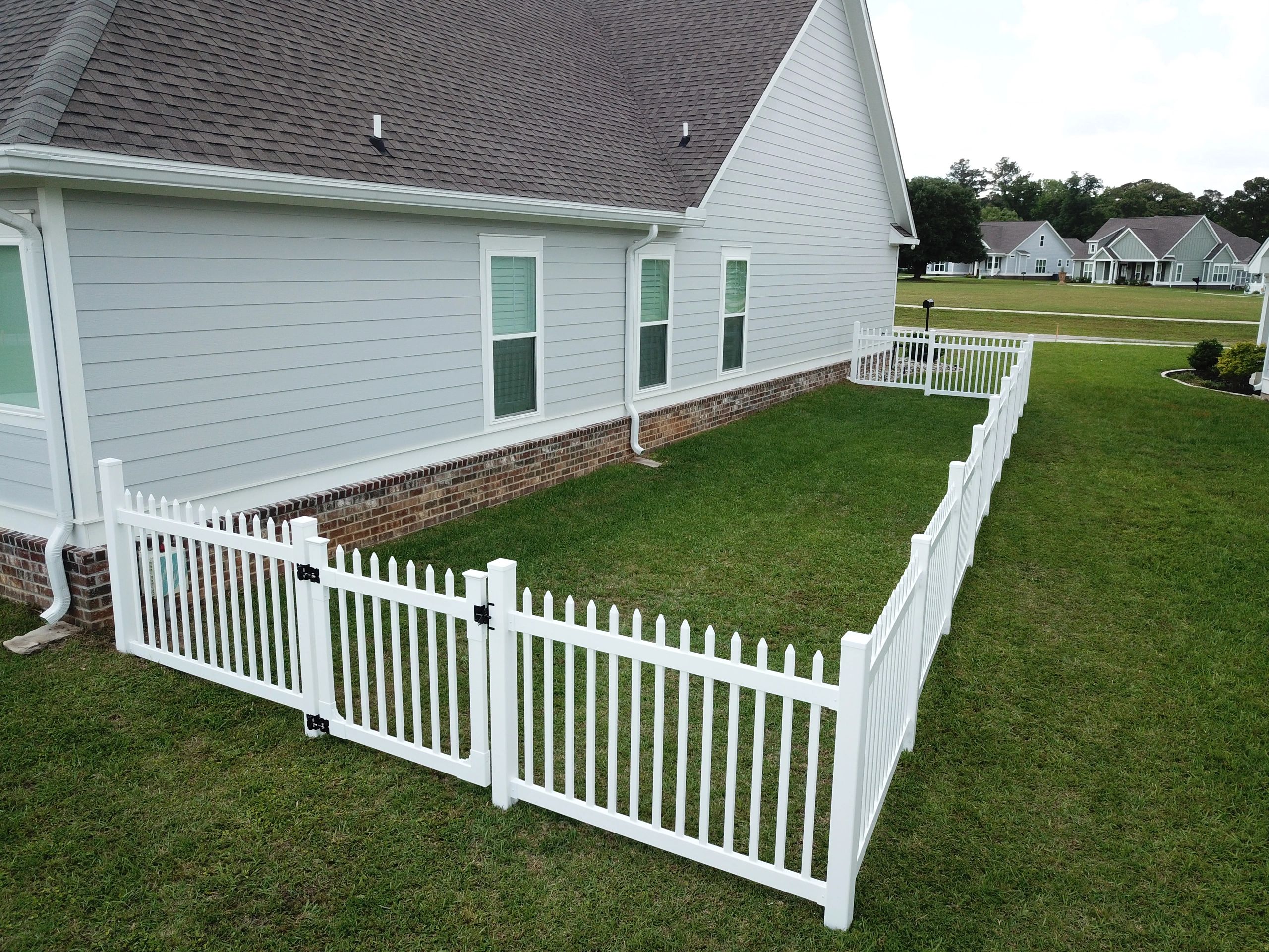 Custom Vinyl Fence on green grass in quaint neighborhood