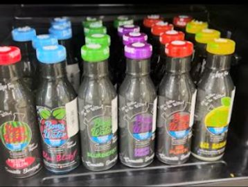 Colorful bottles of various flavors neatly arranged on a shelf.