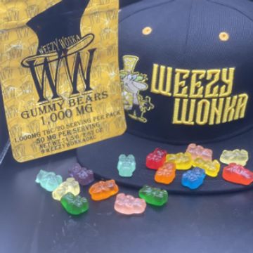 Weezy Wonka gummy bears and branded cap arranged on a black surface.