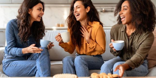 Three women happily chatting over coffee.