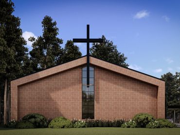 Modern brick church with a large black cross on the facade.