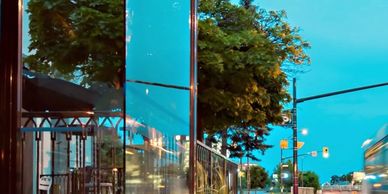 Photo of a bus driving by a glass retail/office building