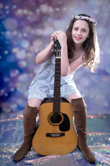 tween girl sitting with guitar