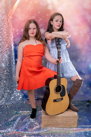 two tween girls pose with guitar