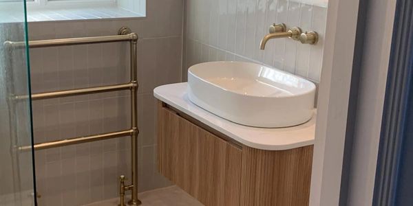 Modern bathroom with a vessel sink and brass fixtures.