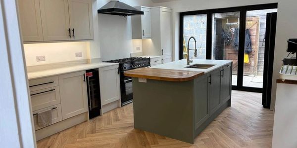 Modern kitchen with island and wooden floor.