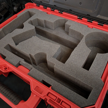 Red carrying case with custom foam insert for equipment protection.