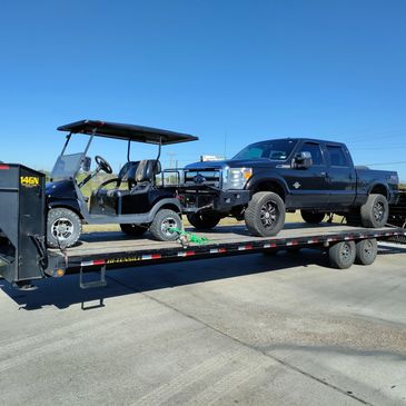Pickup truck and golf cart on gooseneck trailer