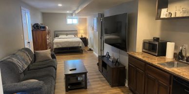 Cozy studio apartment with bed, sofa, and kitchenette.