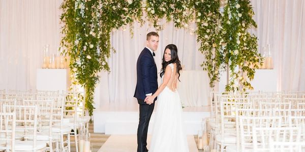 Couple Standing Under Wedding Arbor