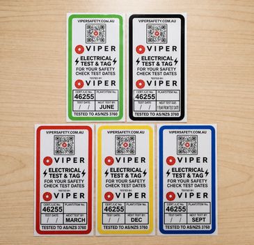 Set of five electrical test and tag safety labels with different colors and dates.
