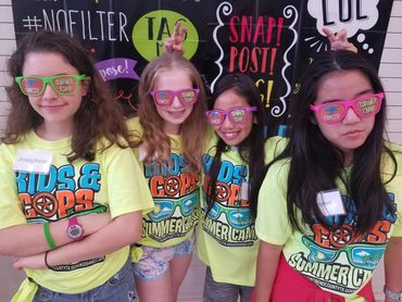A group of girls wearing yellow shirts and pink glasses.