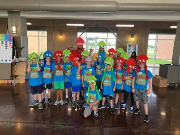 A group of children wearing green hats and shirts.