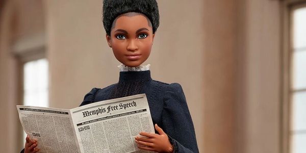 A doll holding a newspaper titled 'Memphis Free Speech'.