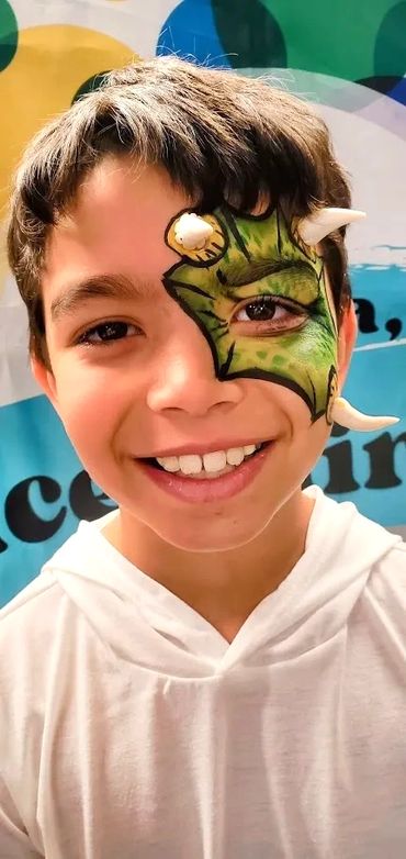 Boy with dinosaur face paint with 3D horns