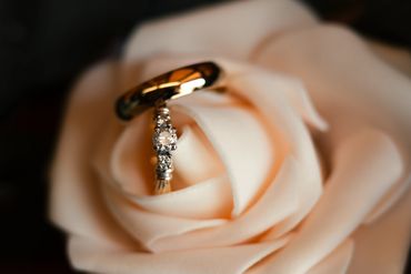 Two rings nestled within a soft peach rose's petals.