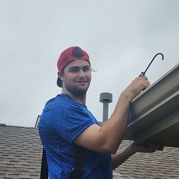 Dylan installing seamless gutters on a client house by North Texas Gutters