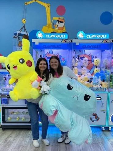 Two females holding large plushies.
