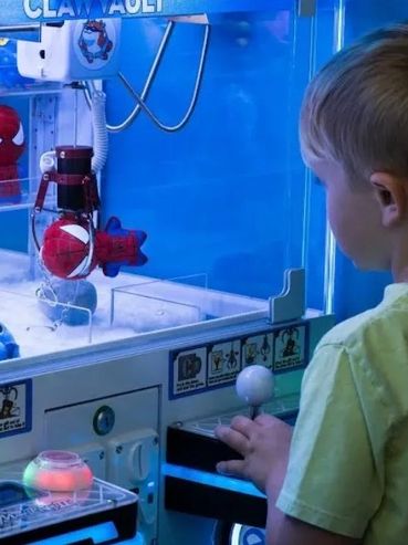 Boy playing a claw machine