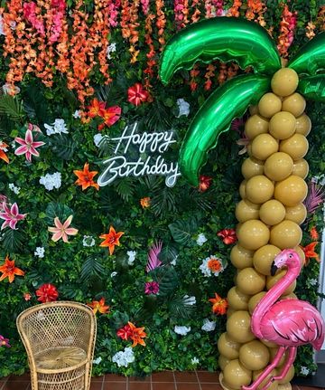 Tropical-themed birthday setup with balloons and flamingo.