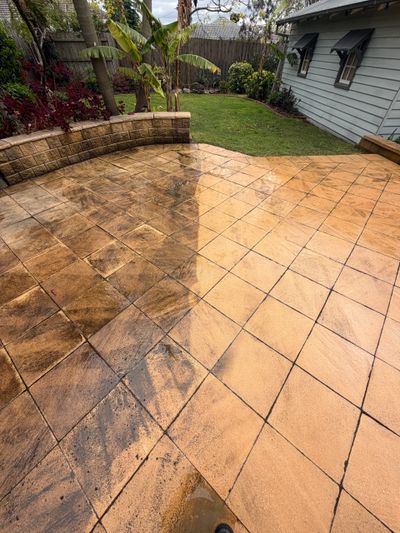 Professional pressure cleaning of outdoor tiled patio showing the transformation between untreated and restored surfaces.