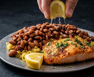 Charcoal-grilled Salmon served with yellow rice, beans, and fresh lemon at Long Ave BBQ, Hillside NJ