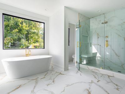 Modern bathroom with freestanding tub and glass shower.